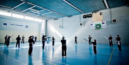 Elèves s'entraînant aux armes dans un gymnase